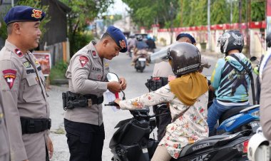 Tunjukkan Rasa Nasionalisme, Brimob Polda Riau Bagikan Bendera Merah Putih ke Masyarakat